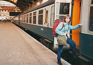 Young woman with a backpack boarding a train