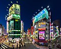 Façades du restaurant Green Peas et du bâtiment Nitori, panneaux néon colorés à l'heure bleue, vues depuis l'avenue Koshu-kaido, gare de Shinjuku JR East. Quartier de divertissement, à Shinjuku (juin 2019).