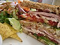 En club sandwich i to lag mellem tre stykker brød