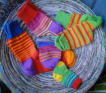 Brightly colored hand knitted socks in a basket