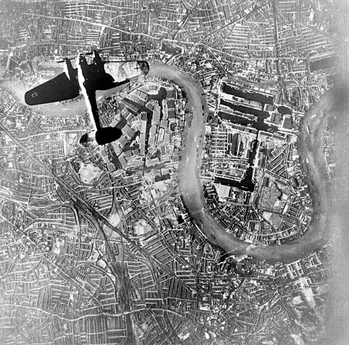 A German Luftwaffe Heinkel He 111 bomber flying over Wapping and the Isle of Dogs in the East End of London at the start of the Luftwaffe's evening ra