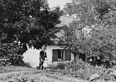 Kvarngården 1915. Framför byggnaden står konstnären Ernst Küsel med sonen Nils.