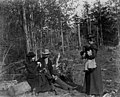 Man and woman sitting on log in woods with woman standing in front of them, ca 1898-1899 (WASTATE 2508).jpeg
