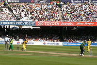 Lee bowling ke Pakistan batsman. Dua pemain lain juga terlihat.