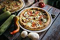 Pizza vegetariana on a wooden rustic table with raw vegetables (49255585361).jpg