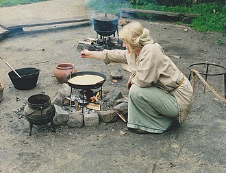 Reconstruction of Iron-age European cookery, using pots suspended in trivets over an open fire Reconstruction of Iron Age cookery with iron trivets over a fire.jpg