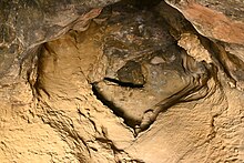 Sandia Cave interior. A partial wall has been built towards the back but the cave continues beyond it. Sandia Cave interior Sandoval County New Mexico 2023-10-15 17-10-28 1.jpg