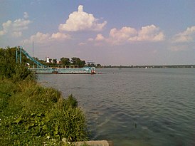 Praia no lago em Shartashskoye, no horizonte - Igreja da Trindade