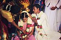 A groom tying the thaali around his bride's neck in a Tamil Hindu wedding