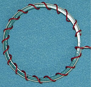 Fig. 4. Circumferential current countered with a return wire. The wire is white and runs between the outer rim of the inductor and the outer portion of the winding. Toroidal Inductor-Simple with Return Wire.JPG