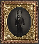 Unidentified young boy wearing secession badge and holding a rifle