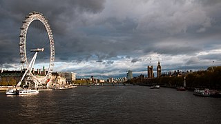 Westminster Bridge view from the southern Golden Jubilee Bridge, with highlights of the London Eye and the Palace of Westminster.jpg