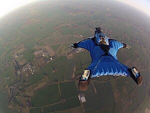 Wingsuit flyer over fields in the UK Wingsuit Flying over Langar Airfield UK.jpg