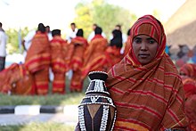 A Somali woman showing a decorated pottery A Somali woman shows traditional items during the culture week.jpg