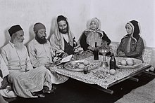 משפחה יהודית-תימנית לאחר ארוחת צהריי שבת, נותרים לסוב את שולחן האוכל, על מנת לפצוח בקריאת מזמורי תהילים, 1947