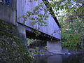 Ada Covered Bridge looking upward. Truss member ends can be seen protruding below sheathing. Very top of truss is visible above sheathing gap below roofline. This gap admitted light, making the bridge interior usable, if somewhat dark.