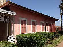Jednopatrový růžový dům se zavřenými okenicemi