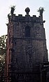 Garland impaled on pinnacle of church tower after being hauled from the shoulders of the Garlan King at the end of the procession, Garland Day (May 29), Castleton, Derbyshire, c1976