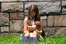 A young woman reading outdoors in New York (2009). Cute girl reading outdoors.jpg