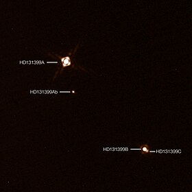 Image composite montrant HD 131399 Ab dans le système HD 131399. Elle a été obtenue par le Très Grand Télescope, et créée à partir de deux images séparées de SPHERE : l'une pour les trois étoiles et l'autre pour la planète. La planète apparaît plus brillante sur l'image qu'elle ne le serait en réalité en comparaison des trois étoiles.