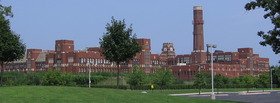 The west and rear of the school. The clock tower is visible to the right of center, and to the left of the taller smokestack. LaneTechRearView.png