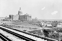 The completed Alberta Legislature Building in 1914, just above the last Fort Edmonton. The city was selected as Alberta's capital in 1905. LegislatureFortEd.jpg