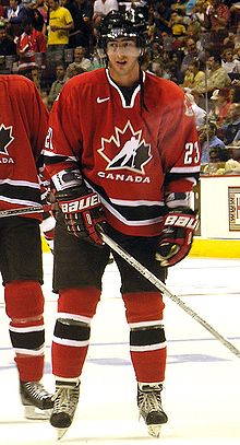 Photo de Luc Bourdon portant le maillot rouge à feuille d'érable de l'équipe du Canada.