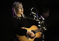 A woman plays guitar.