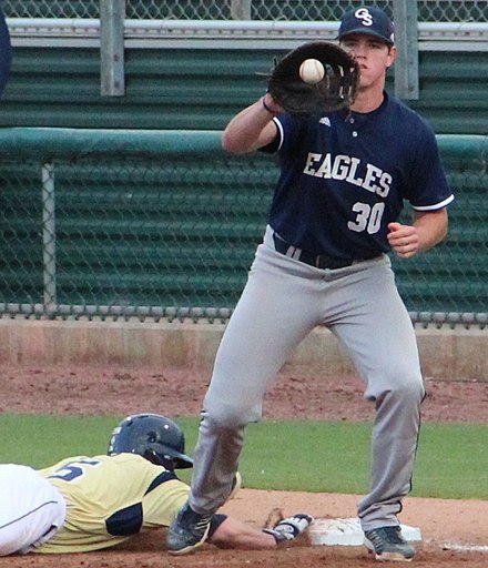 An Eagles baseball player fields a pickoff throw during a 2014 game