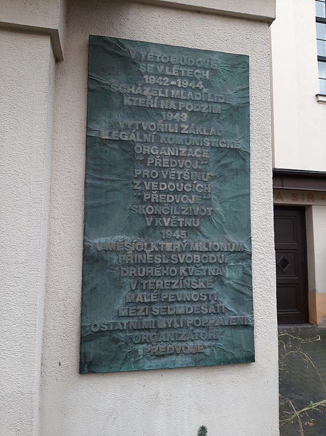 Pohled na pamětní desku, na níž je nápis V této budově se v létech 1942–1944 scházeli mladí lidé, kteří na podzim 1943 vytvořili základ ilegální komunistické organizace „Předvoj“. Pro většinu z vedoucích „Předvoje“ skončil život v květnu 1945 v měsíci, který miliónům přinesl svobodu. Druhého května v terezínské Malé pevnosti mezi sedmdesáti ostatními byli popraveni organizátoři „Předvoje“.