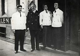 Dørvakt B. Stålkrantz og tre servitører, ca. 1940. Fotograf ukjent. Foto eiet av Oslo museum.