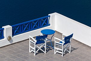 Terrasse avec table et fauteuils aux couleurs de l'architecture cycladique, à Fira, sur l'île de Santorin. (définition réelle 5 410 × 3 607)