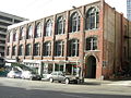 The Scheuerman Block is an example of the Victorian interpretations of the Romanesque Revival frequently applied to buildings erected shortly after the Great Seattle Fire