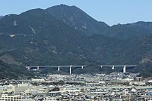 新清水JCT - 新静岡IC間に位置する猿田川橋と巴川橋。静岡市街から一望できる場所にあるこの橋は、竜爪山の麓に位置し、山岳地形に溶け込む橋梁形式が求められた[393]。このことから、通常はコンクリートである箱桁側面を透過性のあるトラスに置き換えた[394]。柱頭部はトラスのイメージでV字とした。