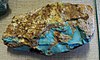 A rough nodule of turquoise in brown matrix with a split face showing areas of intense turquoise blue.