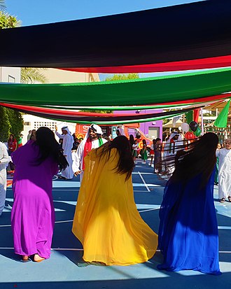 An Emirati folk dance, the women flip their hair sideways in brightly coloured traditional dress. UAE Folk Dance- Khaliji.jpg