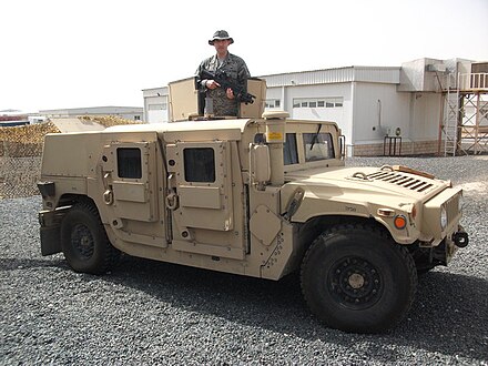 A U.S. Air Force airman in Southwest Asia stands in the ring mount of a FRAG 6-reinforced HMMWV, 2010