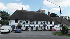 The Ship pub, a large 2-storey building painted white with a thatched roof