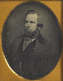 Photograph of a man facing left, with chin beard and longish hair