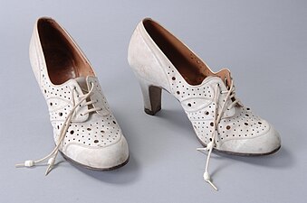 White nubuck lace-up shoes with decorative holes, c. 1935–1940.