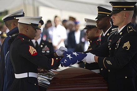 A joint military honor guard folds a US flag over Inouye's casket at the National Memorial Cemetery.