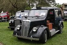 Until the late 1950s, vehicles licensed as London taxis were required to be provided with a luggage platform, open to the street, on the pavement (sidewalk) side, at the front, beside the driver, in place of the front passenger seat found on other passenger cars (including taxis licensed for use in other British cities). 1937BeardmoreTaxi.jpg