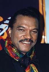 Un sonriente Billy Dee Williams mirando directamente a la cámara.