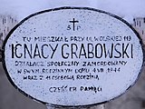 1=Brzozowy krzyż i tablica upamiętniająca męczeńską śmierć 11-to osobowej rodziny Ignacego Grabowskiego na Woli)