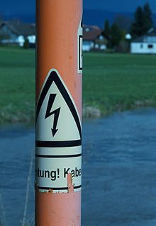 An underground cable marker. Markers are put at regular intervals to show the route and warn of the hazard of digging into the cable. Bogenbach bei Baerndorf Pfahl1.JPG