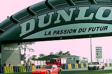 Dodge Viper RT10 - Rene Arnoux, Justin Bell & Bertrand Balas and Porsche 911 Carrera RSR - Laffite, Almeras & Almeras head under the Dunlop Bridge at the 1994 Le Mans (31130404004).jpg