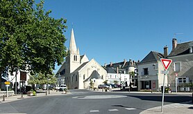 Kleurenfoto van een stadscentrum met een kerk op de achtergrond.