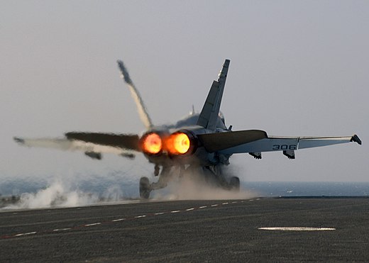 A U.S. Navy F/A-18 Hornet being launched from the catapult at maximum power
