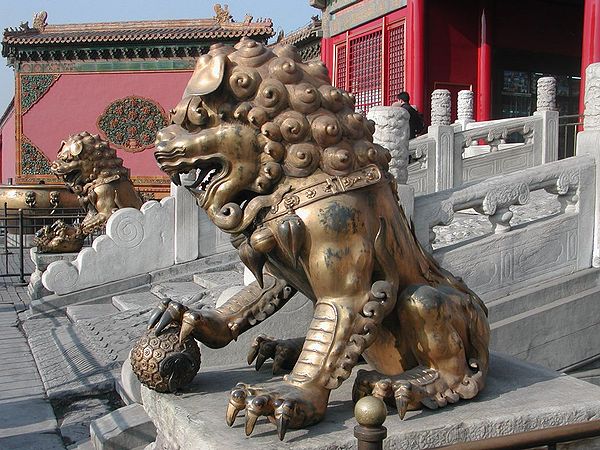 A Qing-era guardian lion pair in the Forbidden City. Note the different appearance of the face and details in the decorative items, compared to the ea