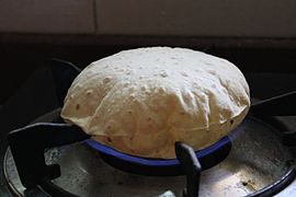 Chapati yang dimasak di atas api langsung untuk mengembangkannya setelah dimasak setengah matang dengan tava.